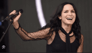 アイルランドンの歌手アンドレア・コア—のがステージ上でマイクを持っている写真